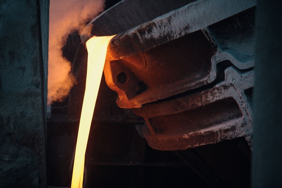 Professional industrial scene showing three types of induction furnaces side-by-side in a modern foundry: coreless (compact, medium-frequency), channel (looped molten metal configuration), and vacuum VIM (sealed chamber with vacuum gauges and cooling lines)